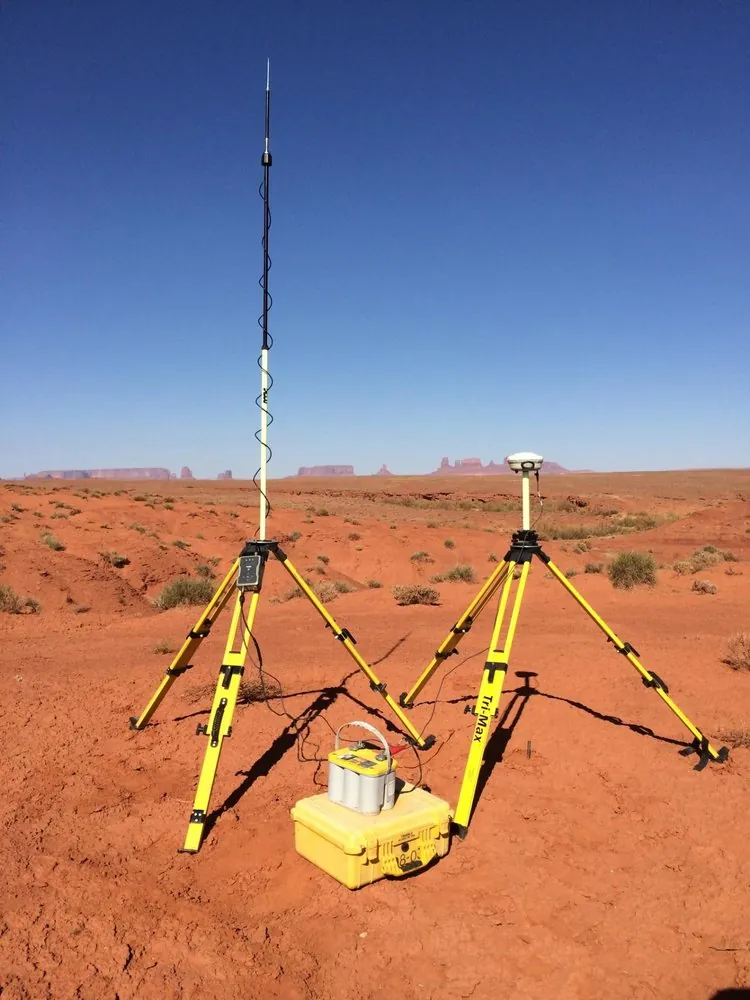 GPS survey equipment set up on red desert soil