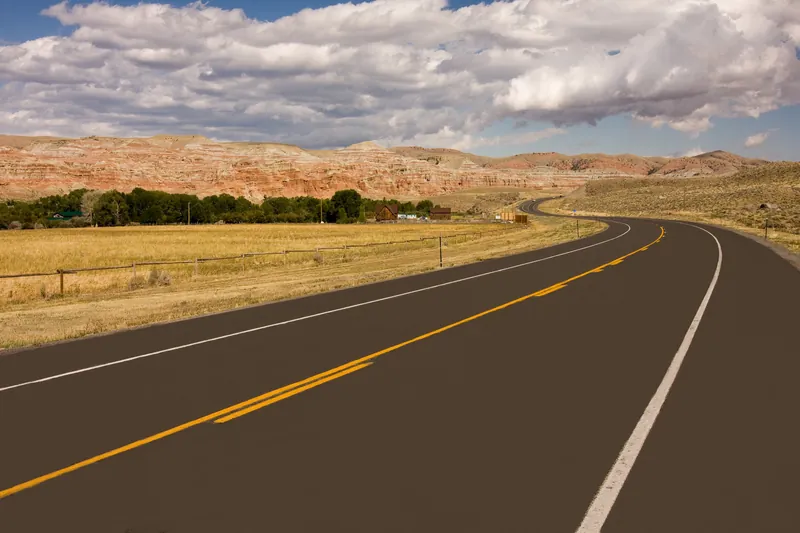 A two-lane highway curving through open range